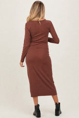 woman wearing a brown long sleeve maternity dress, showing a fitted style and mid-calf length from the back.