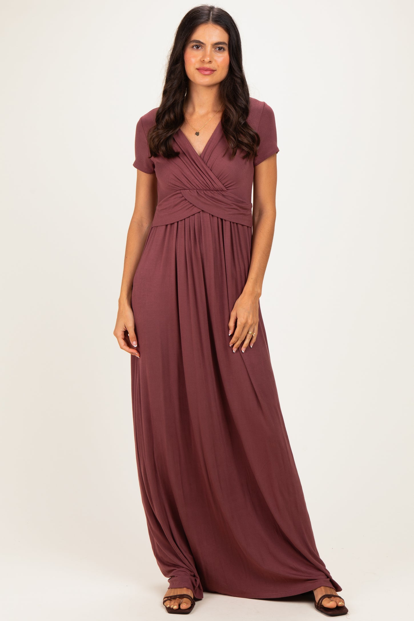 woman wearing a burgundy short sleeve maxi dress with wrap detail and flowing skirt