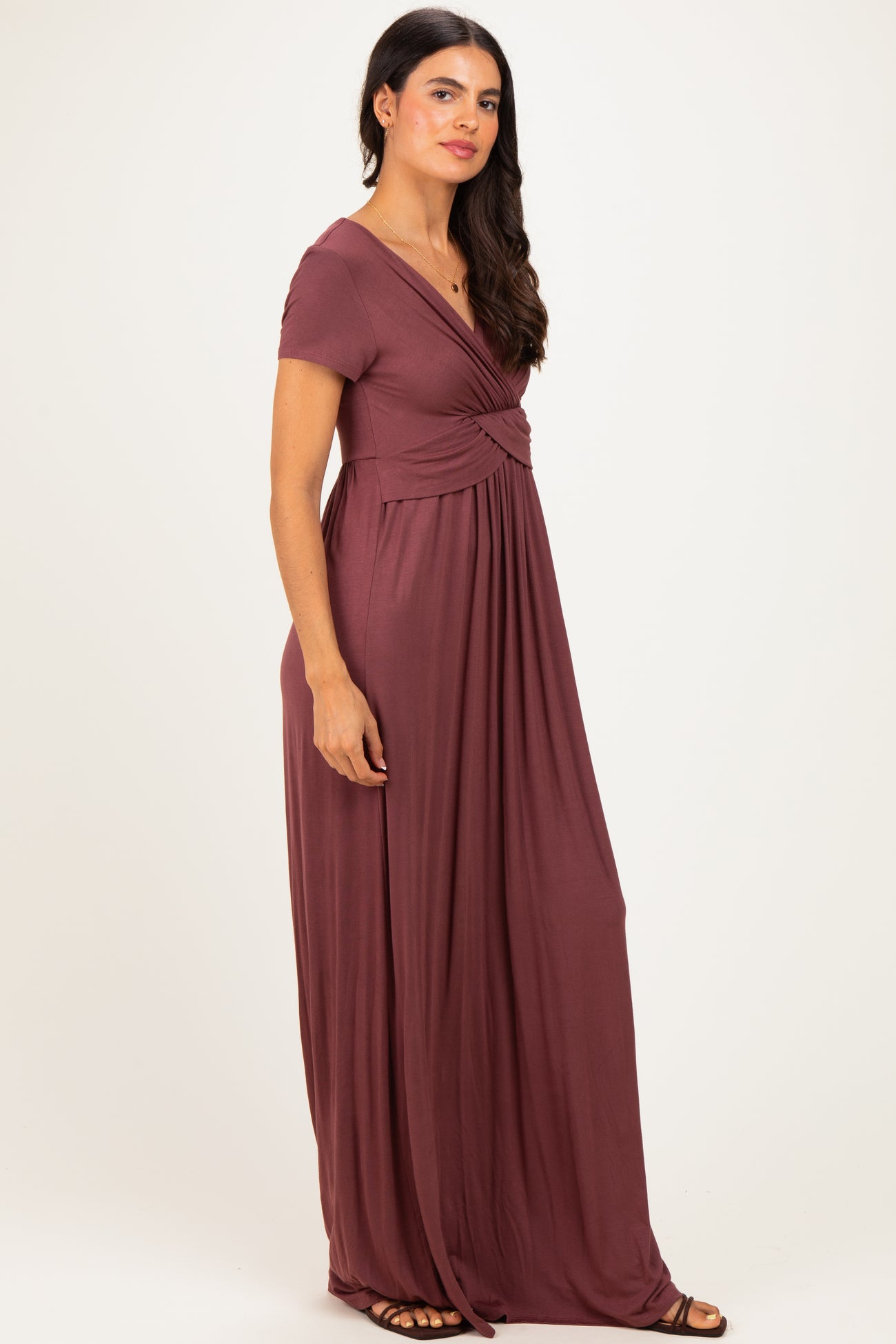 woman wearing a burgundy short sleeve maxi dress with a twist front and flowy skirt