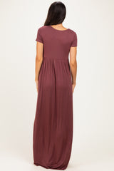 woman wearing a burgundy short sleeve maxi dress with a fitted bodice and flowy skirt from the back