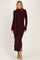 woman wearing a burgundy ribbed long sleeve knit dress with a side slit and matching scarf