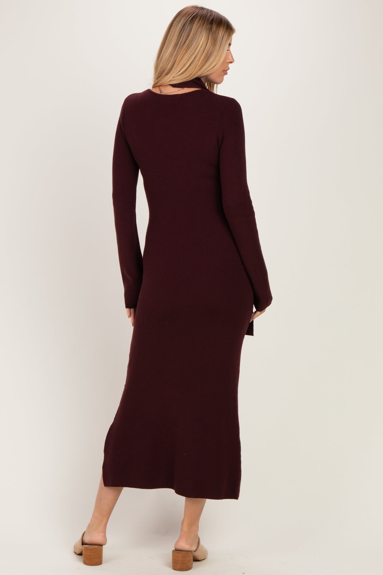 woman wearing a burgundy ribbed long sleeve maxi dress with a fitted silhouette and side slit