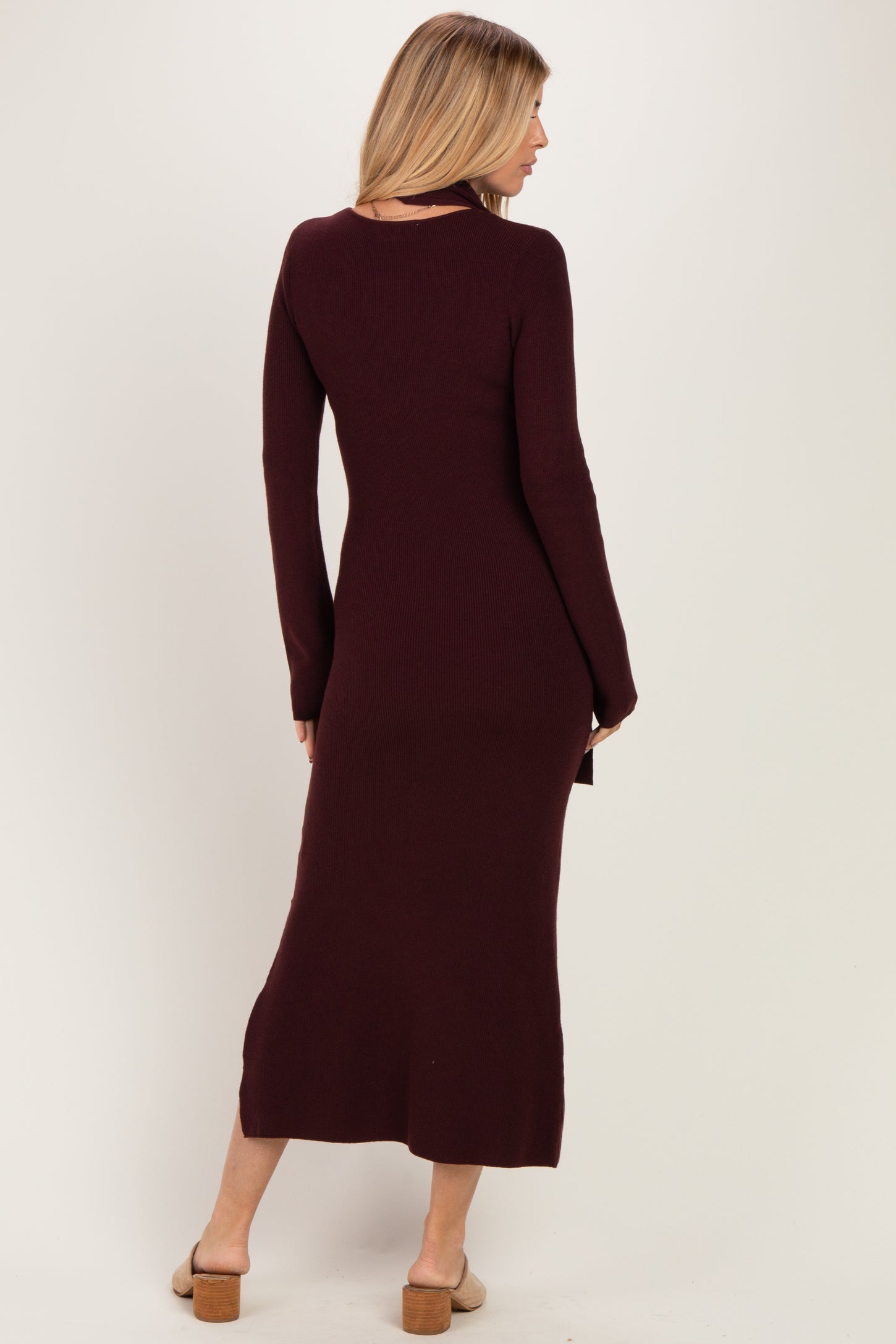 woman wearing a burgundy ribbed long sleeve maxi dress with a fitted silhouette and side slit