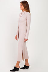 woman wearing a light pink long sleeve ribbed maxi dress with a side slit and a collar, styled with black mules