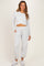 woman wearing a light gray long sleeve cropped maternity top and matching relaxed-fit maternity joggers