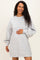 woman wearing a gray maternity sweatshirt dress with long balloon sleeves and holding her baby bump