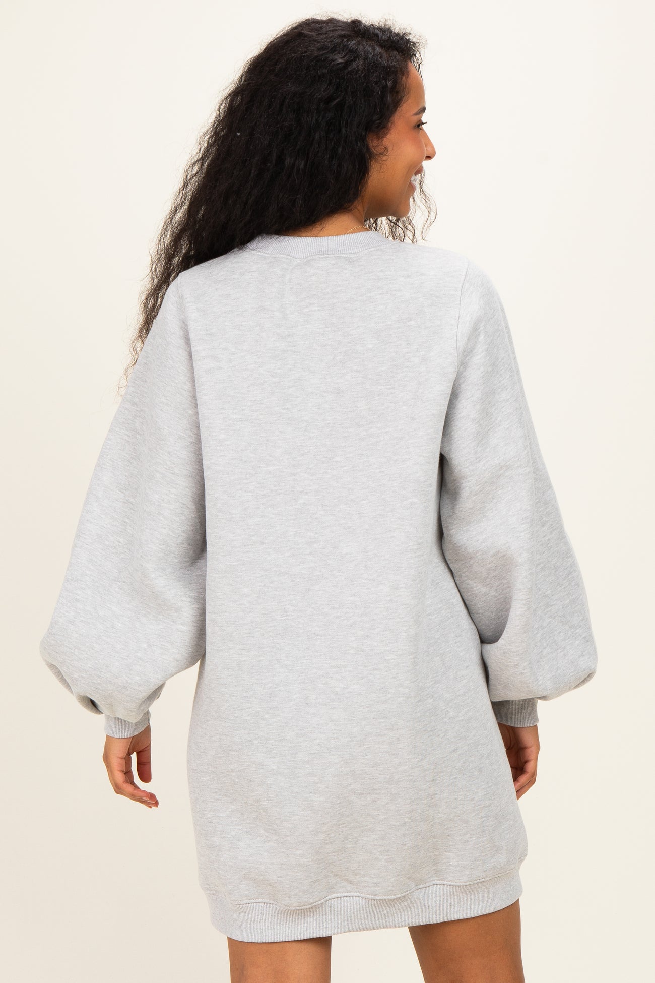 woman wearing a gray maternity sweatshirt dress with balloon sleeves, facing away from the camera