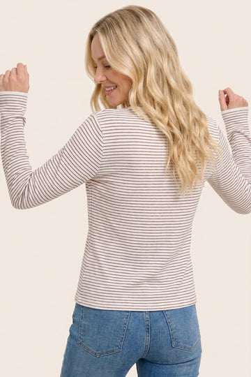 woman wearing a thin striped long sleeve top with a round neck and back view, paired with light blue jeans