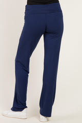 woman wearing navy blue stretchy pants with a foldover waistband and white sneakers seen from the back