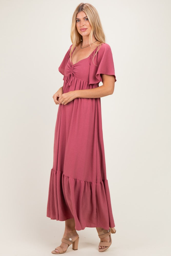 woman wearing a dusty rose maxi dress with flutter sleeves and a tie-front detail