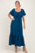 woman wearing a teal maxi dress with short sleeves, a square neckline, and a tiered skirt