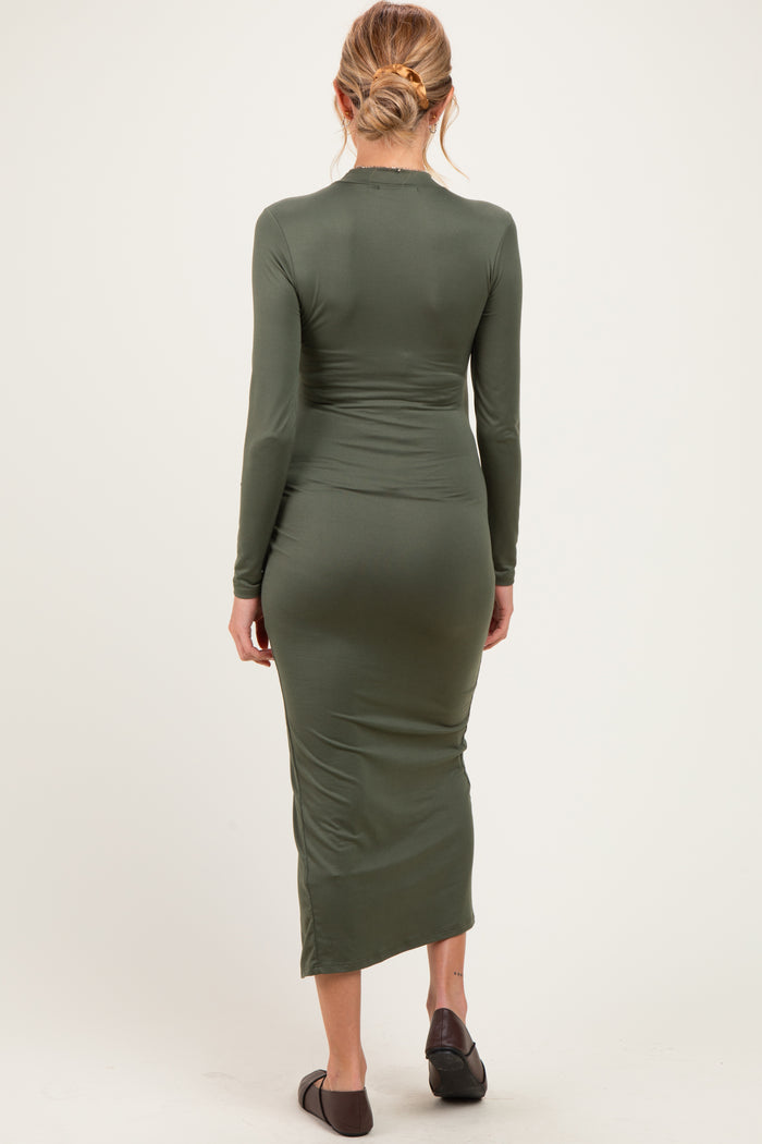 woman wearing a dark green long sleeve maternity dress with a fitted silhouette, showing a baby bump from the back
