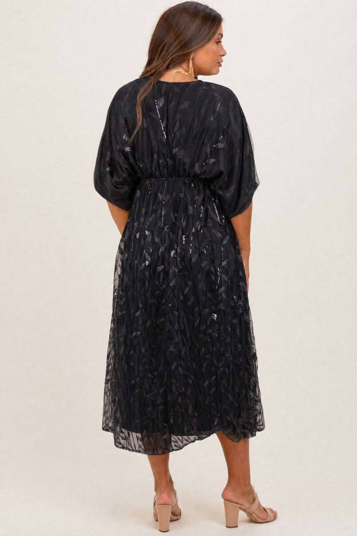 maternity wear black sheer midi dress with flutter sleeves and a fitted waist, model showing the back view