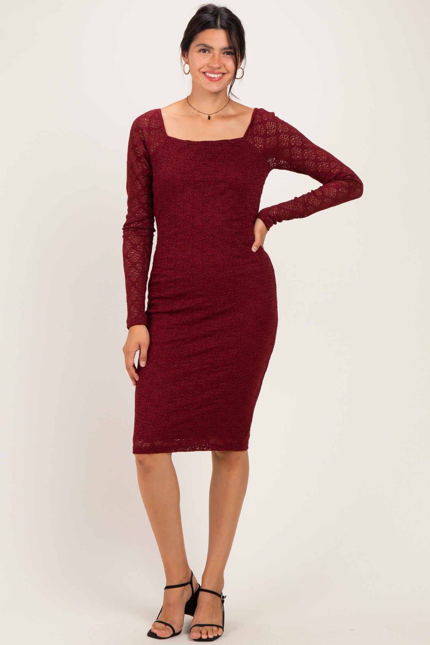 woman wearing a burgundy long sleeve bodycon dress with lace details and a square neckline