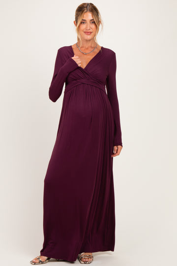 woman wearing a dark purple long sleeve maternity dress with a wrap design and visible baby bump