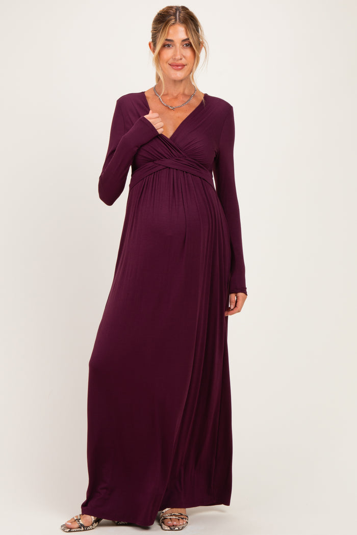 woman wearing a dark purple long sleeve maternity dress with a wrap design and visible baby bump