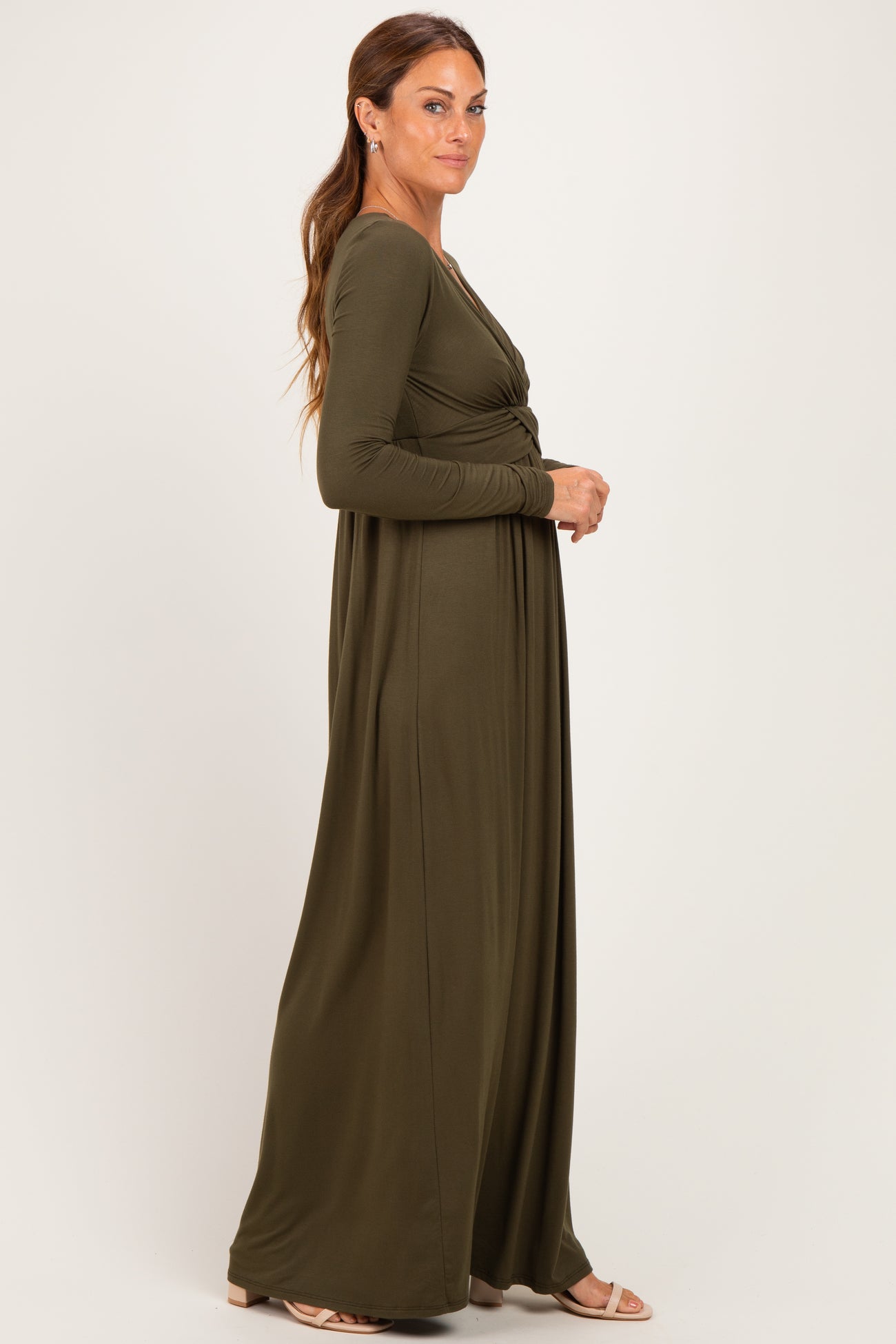 woman wearing a long sleeve olive green maxi dress with a twist front detail