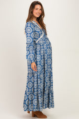 woman wearing a blue patterned long sleeve maternity dress with a flowing skirt and visible baby bump