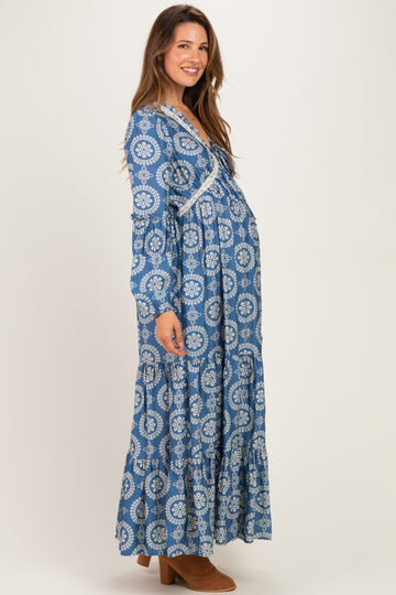 woman wearing a blue patterned long sleeve maternity dress with a flowing skirt and visible baby bump