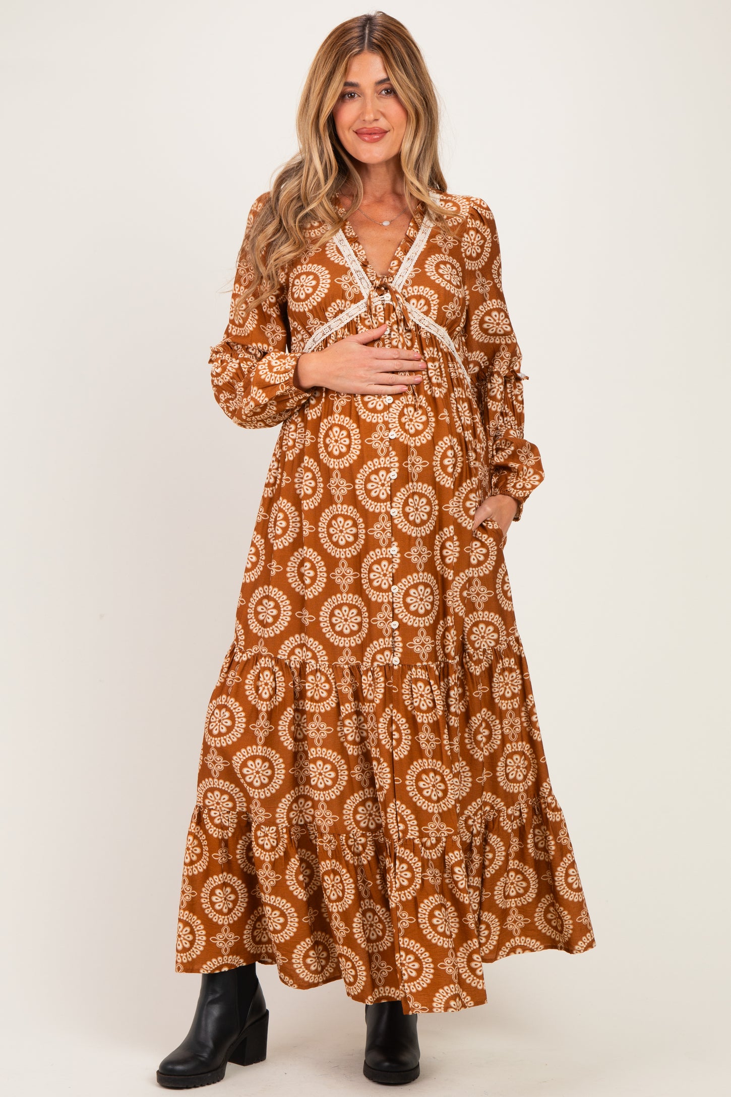 woman wearing a brown floral maternity maxi dress with long sleeves and a baby bump visible