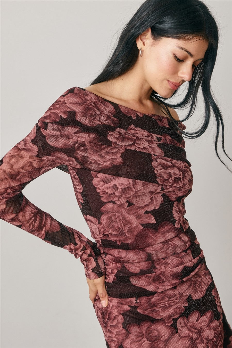 woman wearing a long sleeve off-the-shoulder floral bodycon dress in burgundy and black hues