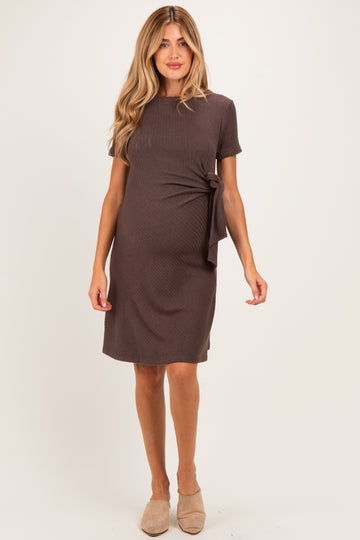 woman wearing a brown short sleeve maternity dress with side tie detail and visible baby bump