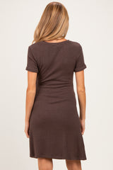 woman wearing a chocolate brown short sleeve maternity dress with a ribbed texture, view from the back