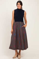 woman wearing a navy sleeveless top and a striped midi skirt with pockets, standing and smiling