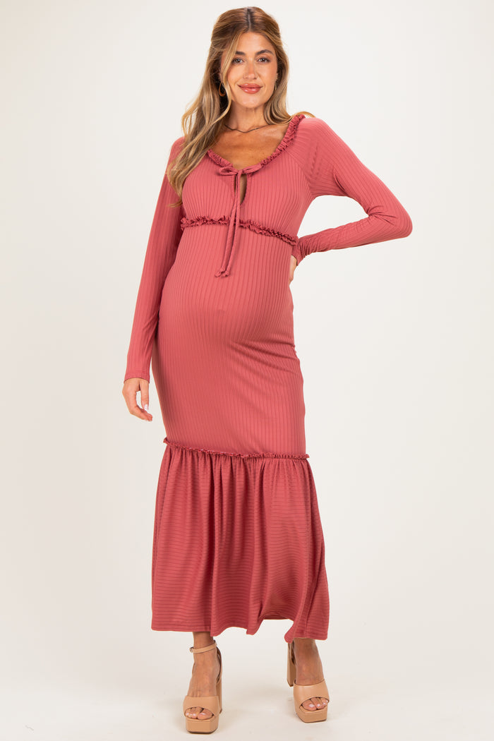 woman wearing a dusty rose maternity maxi dress with long sleeves and a ruffled hem, showing her baby bump