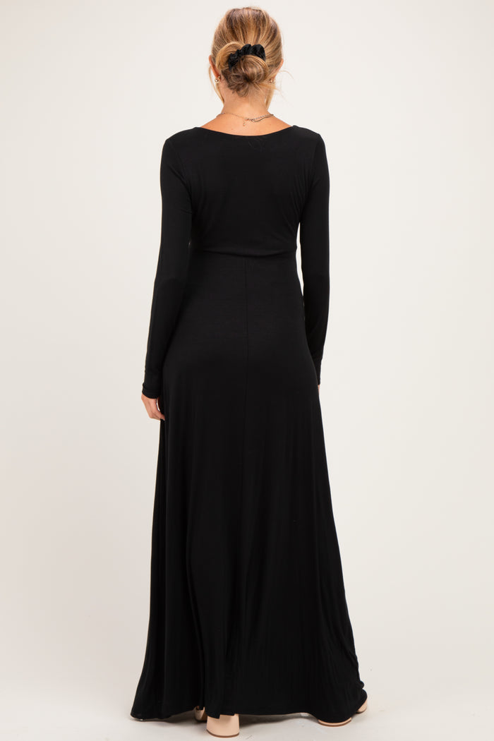 woman wearing a black long sleeve maternity maxi dress, view from the back, showcasing a flowing skirt design