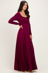 woman wearing a long sleeve burgundy maxi dress with a flattering scoop neckline and flowy skirt
