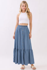 woman wearing a white cropped tank top and a long denim button-up skirt with a tiered hem