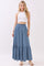 woman wearing a white cropped tank top and a long denim button-up skirt with a tiered hem