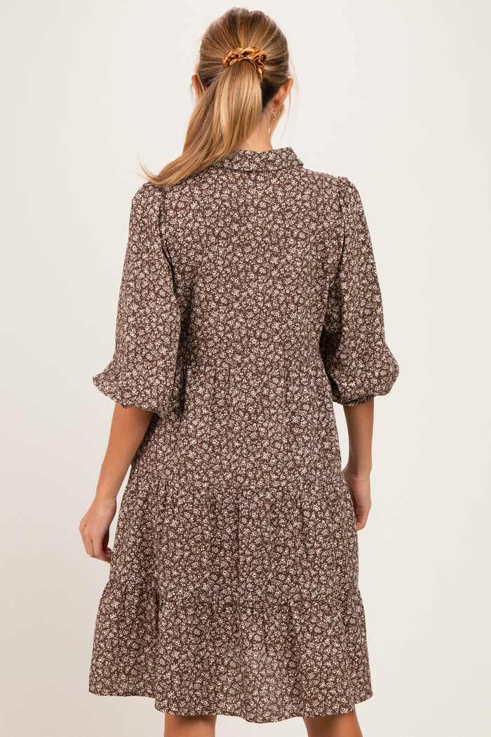 woman wearing a brown floral short sleeve maternity dress with tiered skirt and back button detail