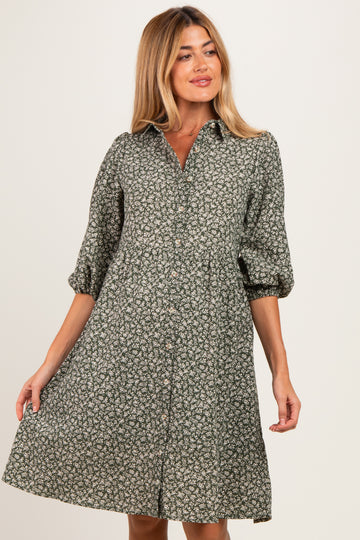 woman wearing a green floral maternity dress with a button-down front and puffed sleeves