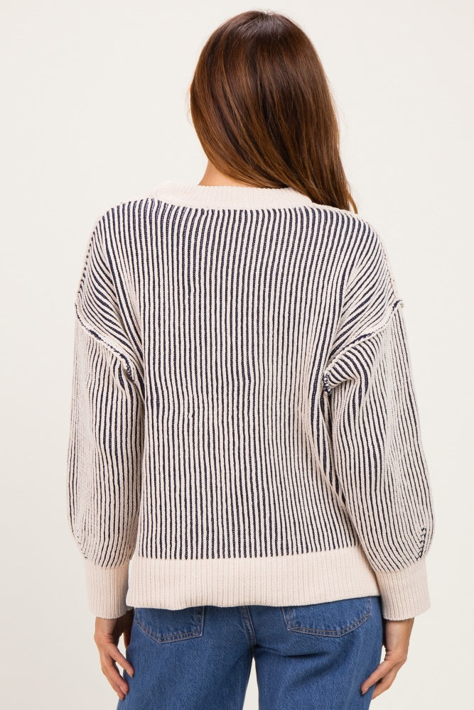 woman wearing a striped navy and cream oversized sweater from the back with balloon sleeves and relaxed fit