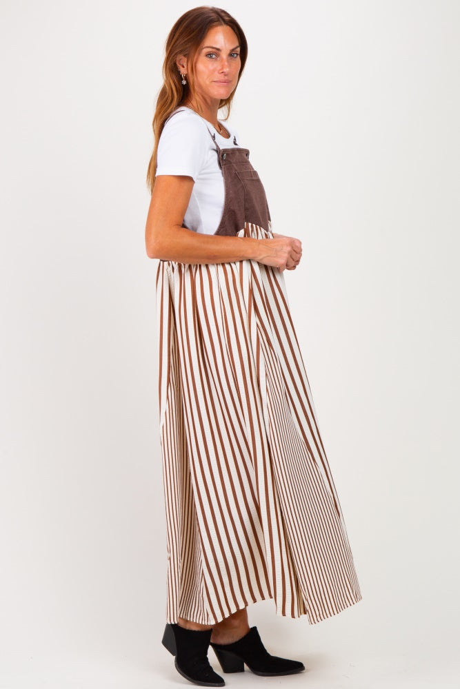 woman wearing a brown and white striped maxi dress with a fitted bodice and flowing skirt, paired with black ankle boots