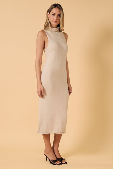 woman wearing a beige sleeveless midi dress with a high neck and slim fit, standing against a yellow background