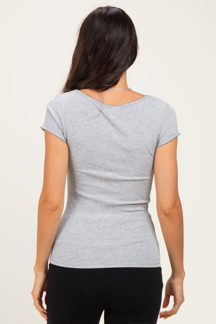 woman wearing a gray short sleeve fitted top, view from the back, showing a smooth silhouette