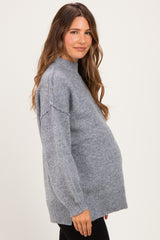 woman wearing a gray maternity sweater with a relaxed fit and a visible baby bump