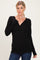woman wearing a black long sleeve wrap top with a fitted waist and v-neckline