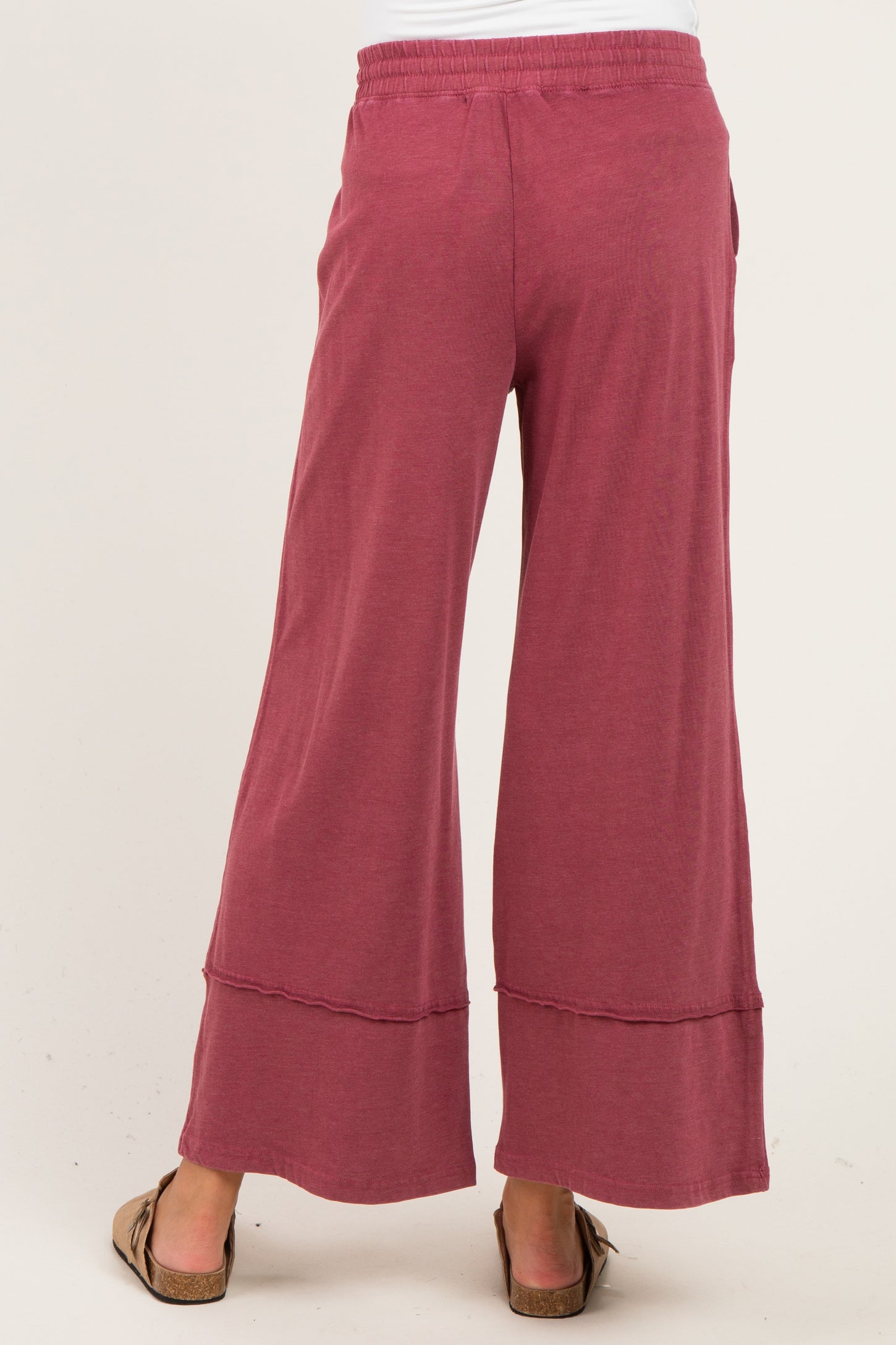 woman wearing a pair of maroon wide-leg maternity pants with a casual, relaxed fit and a stretchy waistband
