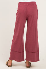 woman wearing a pair of maroon wide-leg maternity pants with a casual, relaxed fit and a stretchy waistband