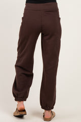 woman wearing brown maternity joggers with pockets, showing the back view and elastic ankle cuffs