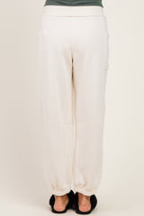 woman wearing cream colored maternity jogger pants with elastic cuffs and side pockets, viewed from the back