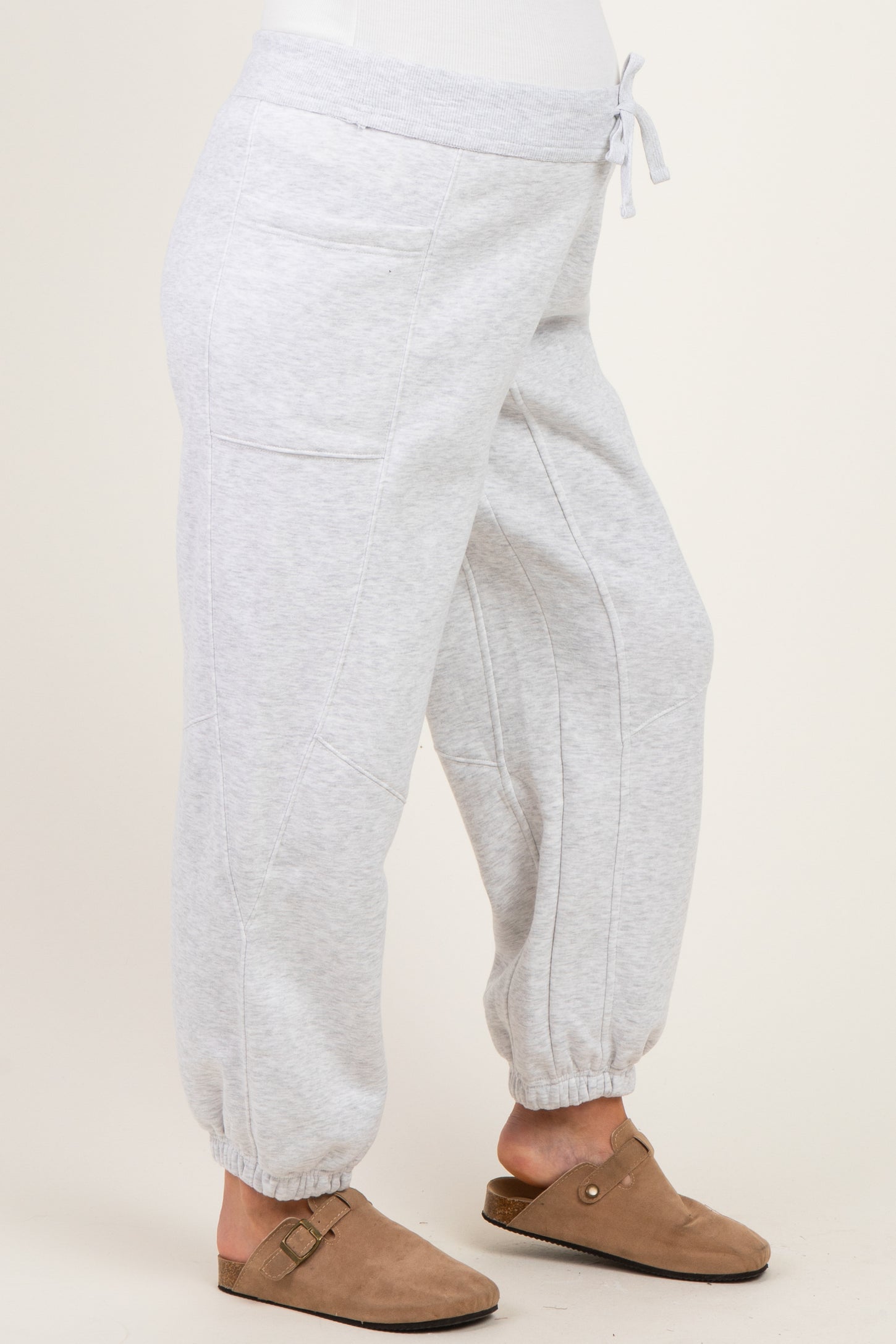 woman wearing light gray maternity sweatpants with a drawstring waist and tapered cuffs