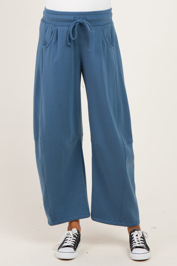 woman wearing a blue wide-leg maternity sweatpants with pockets and a drawstring waist