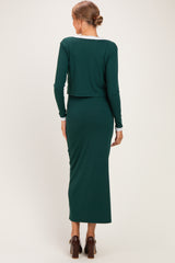 woman wearing a long green ribbed maternity dress with a cropped top and fitted silhouette, showing her baby bump from the back
