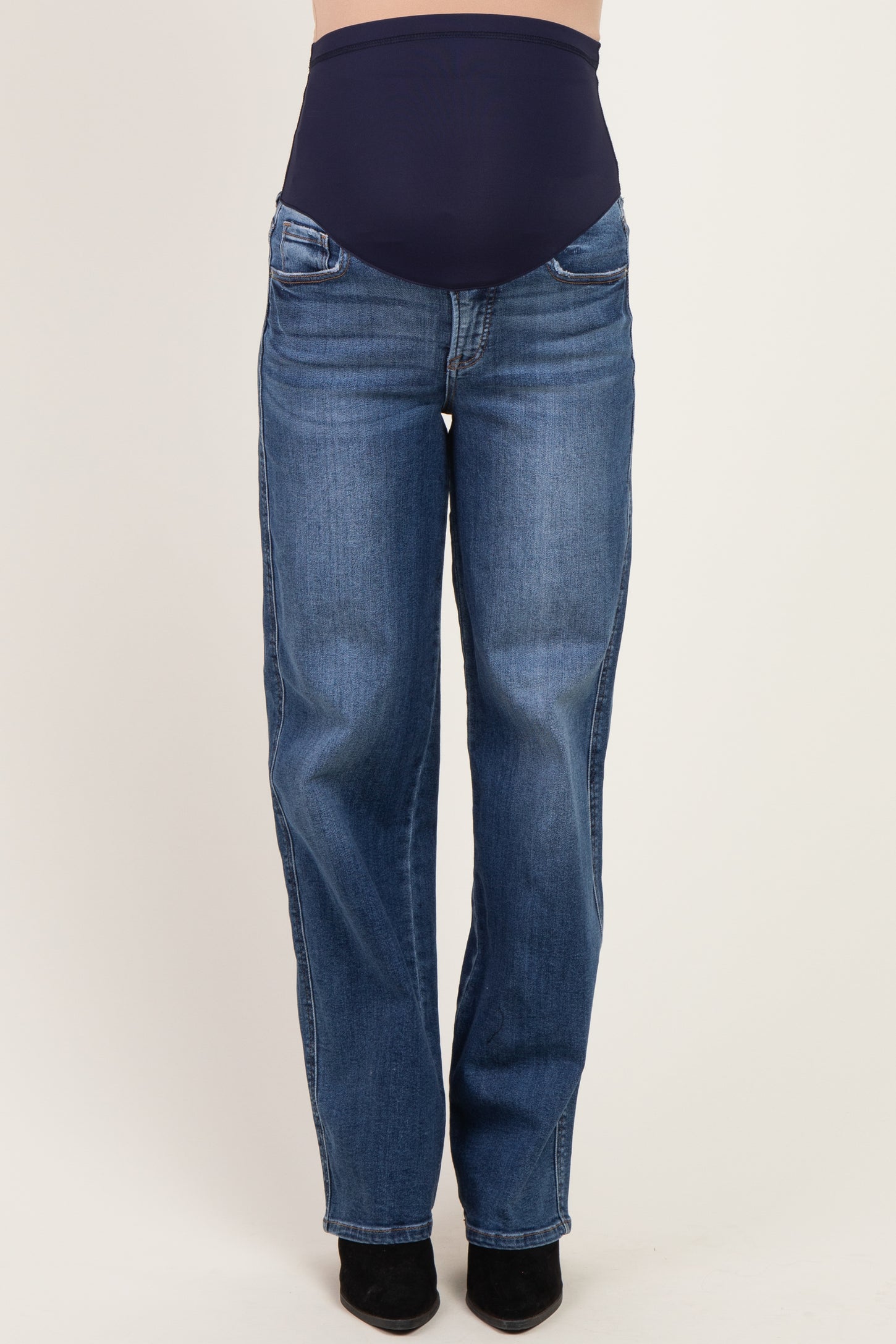 woman wearing dark blue maternity jeans with a supportive waistband and straight-leg fit