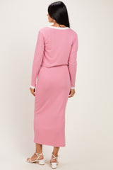 woman wearing a pink ribbed long sleeve top and matching midi skirt, viewed from the back